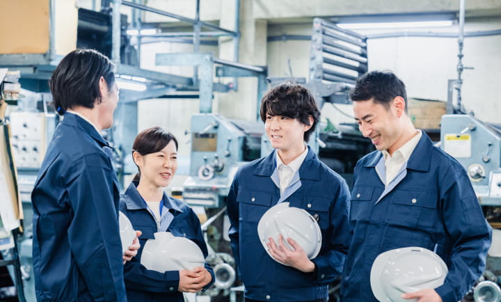 工場で会話する作業者たち
